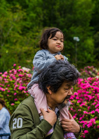 Portrait of friends on red flowering plants