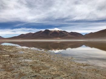 Scenic view of lake by mountains against sky