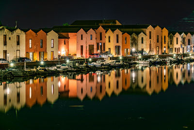 Reflection of illuminated buildings in river at night