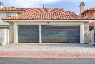 Exterior of house by building in town against sky