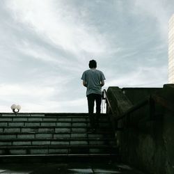 Rear view of silhouette man standing against sky