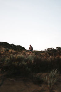 Woman standing on land against clear sky