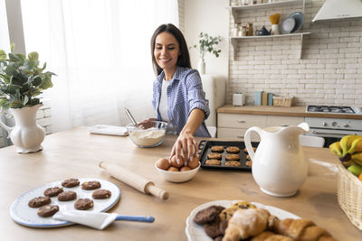 Woman preparing food on table at home