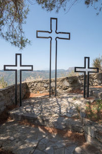 Cross on beach against sky