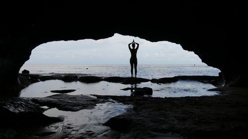 Silhouette man on beach against sky