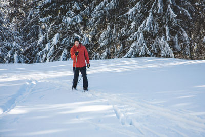 Full length of woman skiing on snow covered field