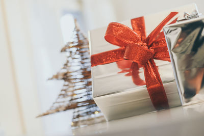 Gift boxes near christmas tree inside home. box with holiday ribbon with bows. festive atmosphere