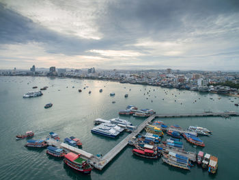 High angle view of boats moored at harbor in city against sky