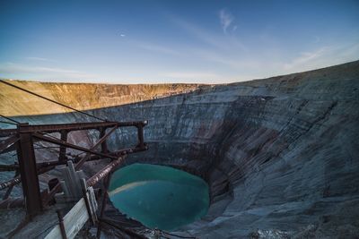 Scenic view of dam on mountain against sky