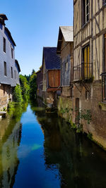 Canal amidst buildings against sky