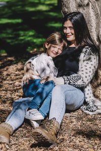 Young woman with baby sitting outdoors