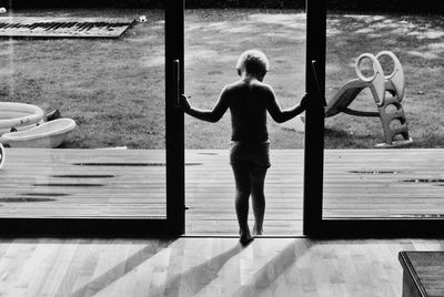 Rear view of girl playing on swimming pool