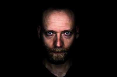 Portrait of man against black background