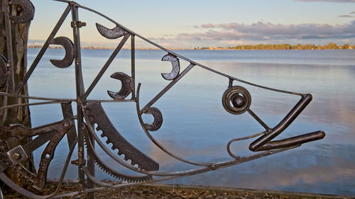 Close-up of metallic railing against sky