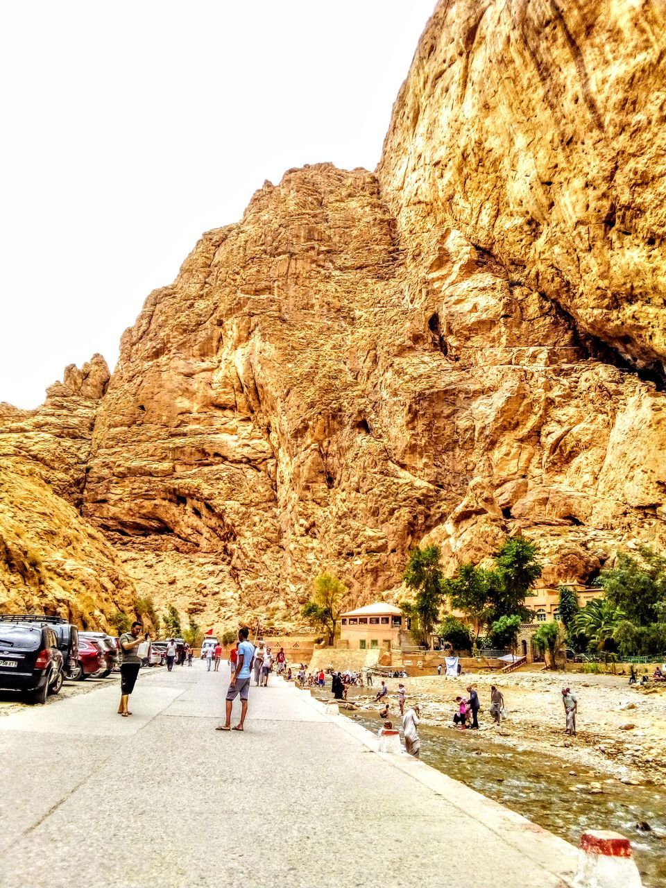 group of people, wadi, rock, rock formation, nature, transportation, large group of people, travel, mountain, day, valley, men, travel destinations, leisure activity, sky, crowd, mode of transportation, adult, land, women, lifestyles, outdoors, tourism, beauty in nature, walking, road, geology, physical geography, motor vehicle, formation, scenics - nature, plant, architecture, land vehicle, tourist, clear sky, terrain, holiday, vacation, car, trip, rocky mountains, non-urban scene, sunlight, mountain range