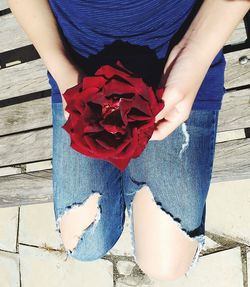 Midsection of person holding red flower