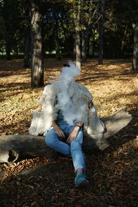 Man smoking while sitting in forest