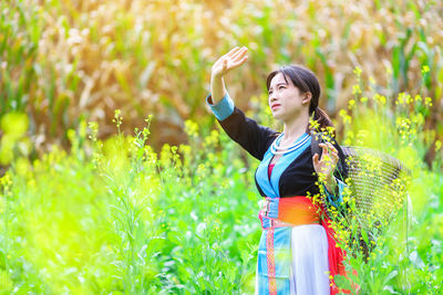 Young woman looking away while standing on land