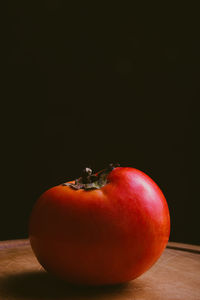 Close-up of apple on table against black background