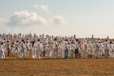 Group of people on field against sky