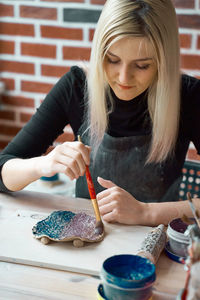 Artist painting clay at workshop