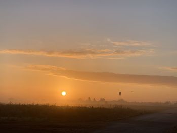 Scenic view of silhouette field against sky during sunset