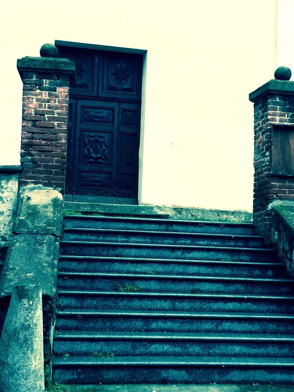 architecture, built structure, building exterior, steps, steps and staircases, entrance, low angle view, staircase, door, wall - building feature, closed, old, clear sky, building, no people, history, outdoors, stairs, railing, day