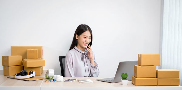 Cheerful woman looking at laptop while sitting at office