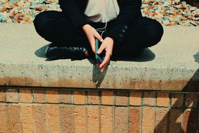 Low section of woman sitting outdoors