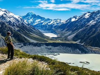 Full length of man looking at view against snowcapped mountains