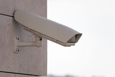 Low angle view of security camera against clear sky