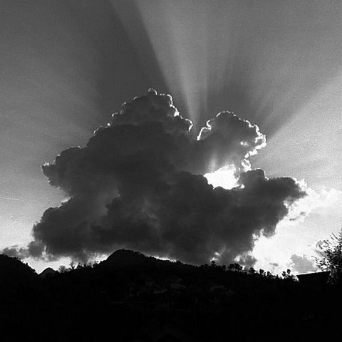 sky, silhouette, cloud - sky, scenics, low angle view, beauty in nature, mountain, tranquil scene, tranquility, cloudy, nature, weather, cloud, idyllic, dusk, outdoors, sunbeam, landscape, overcast, mountain range