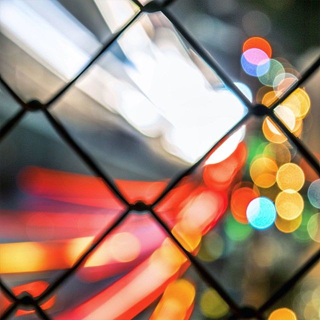 metal, lighting equipment, illuminated, close-up, focus on foreground, multi colored, hanging, low angle view, no people, protection, metallic, selective focus, safety, indoors, railing, yellow, electricity, security, electric light