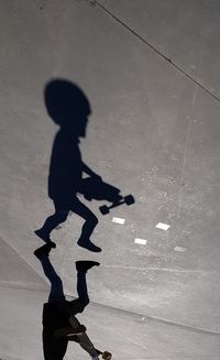 High angle view of silhouette man walking on street