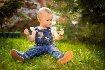 Full length of cute girl sitting on grass