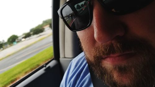 Close-up portrait of bearded man in car