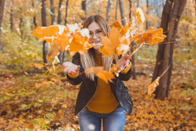 Young woman holding autumn leaves