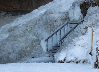 Snow covered staircase against snowcapped mountain