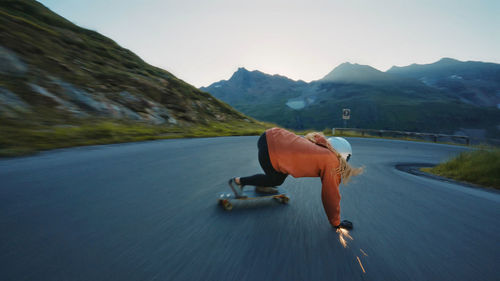 Rear view of woman sitting on boat in lake