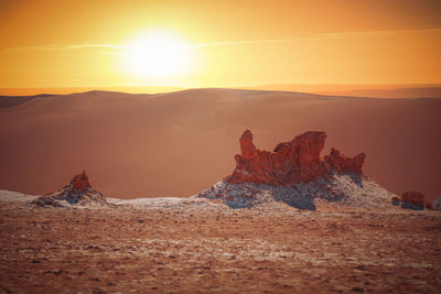 Rock formation on land against sky during sunset