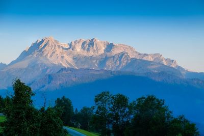 Scenic view of snowcapped mountains against clear blue sky