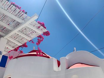 Low angle view of flags hanging on building against sky