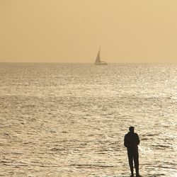 Man standing on sea against sky