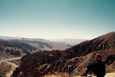 Man standing on mountain against clear sky