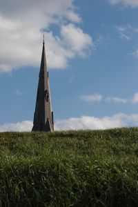 Traditional windmill on field against sky