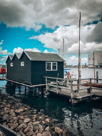 Houses by sea against sky