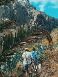 Rear view of men walking on mountain