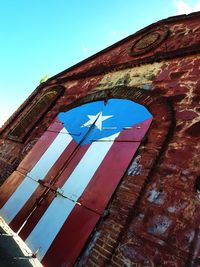 Low angle view of flags against clear blue sky