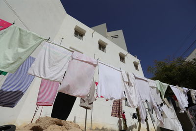 Low angle view of clothes drying on building against sky