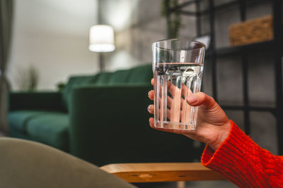 Midsection of woman holding wineglass